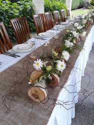 A 4.5m long table design suitable for a wedding birch wood slices white flowers and Muehlenbeckia twigs